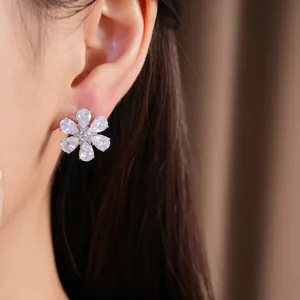 Detailansicht eleganter Blumenohrstecker mit funkelnden klaren Zirkonia-Blütenblättern am Ohr
