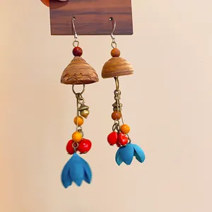 Close-up of vintage ethnic wooden tassel earrings with blue flower pendants