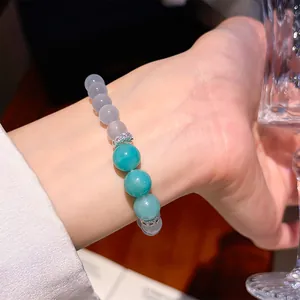 Close-up of beaded bracelet with turquoise and grey beads on woman's wrist