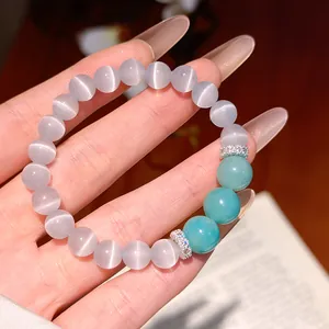 Close-up detail of a cats eye and turquoise resin beaded bracelet featuring zircon spacers