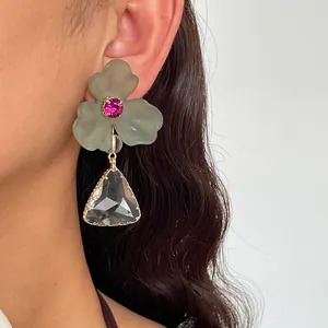 Vue détaillée des boucles d'oreilles fleur en acrylique avec strass triangulaire