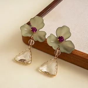 Vue macro de boucles d'oreilles vintage avec fleurs en acrylique et gouttes de cristal.