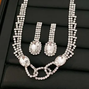 Elegantes silberfarbenes Schmuckset mit ovalen Kristallanhängern und Strasssteinen.