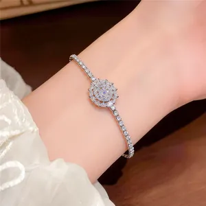 Detailed close-up of a French style silver zircon sunburst bracelet on a delicate wrist