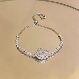 Close-up of sparkling oval zircon pendant with double halo on silver-tone bracelet