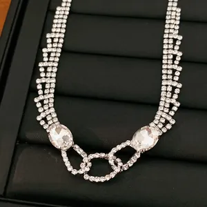 Nahaufnahme einer eleganten Silberkette mit ovalen Kristallen und Strasskette
