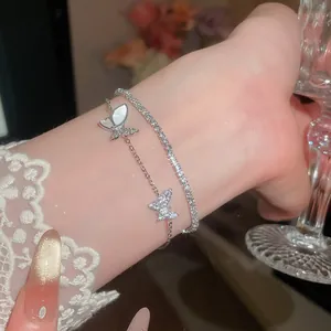 Elegantes doppellagiges Silberarmband mit funkelnden Zirkonia-Schmetterlingen und Muschel.