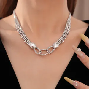 Nahaufnahme einer eleganten silbernen Strasshalskette mit ovalen Kristallanhängern am Model