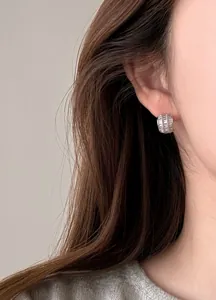 Detailansicht der eleganten silbernen Baguette-Zirkonia-Halbreifen-Ohrringe am Modellohr