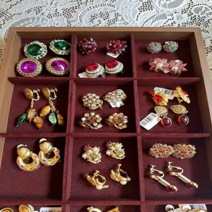 Sortierte Strass- und Perlenohrringe im Vintage-Stil in einem Schmuckdisplay aus Holz