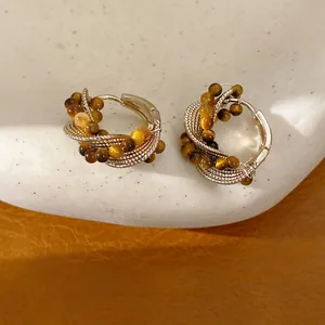 Detailed view of retro tiger eye beaded hoop earrings with twisted metallic texture.