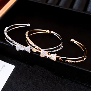 Detailaufnahme der doppelreihigen Armreifen mit Zirkonia-Schleifen in Gold und Silber