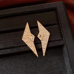 Detailansicht goldener geometrischer Ohrstecker mit funkelnden Zirkonia-Kristallen.