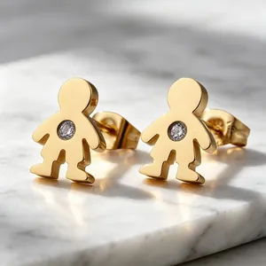 Gros plan de boucles d'oreilles dorées en forme de garçon avec pierre brillante