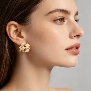 Gros plan de boucles d'oreilles en acier titane doré avec motifs de garçon et fille