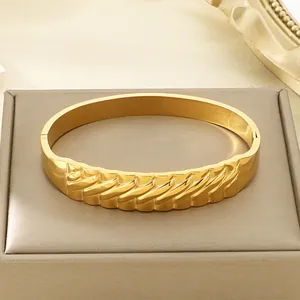 Detailopname van 18k vergulde roestvrijstalen armband met golvend textuurontwerp