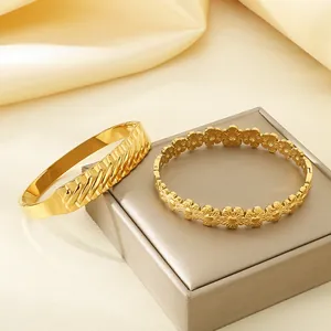 Detailweergave van 18k goud vergulde roestvrijstalen armbanden met bloemmotief en golftextuur