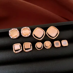Nahaufnahme von Vintage-Ohrsteckern mit pfirsichfarbenen Katzenaugensteinen und Strass