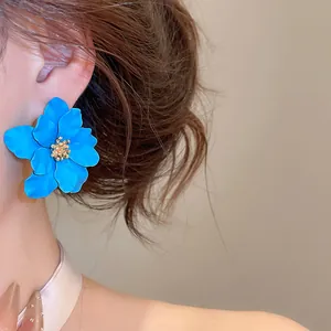 Detailopname van elegante blauwe bloemknopjes met gouden meeldraad op een model
