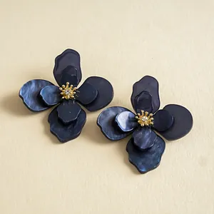 Dettaglio ravvicinato di orecchini vintage in acrilico blu navy marmorizzato con strass
