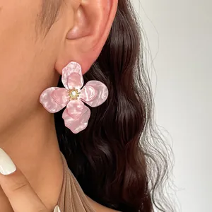 Eleganti orecchini a lobo a fiore in acrilico rosa marmorizzato con strass al centro.