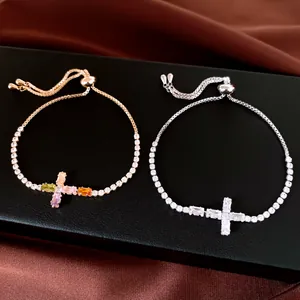 Détail macro de bracelets de tennis ajustables en zircone avec croix dorée et argentée
