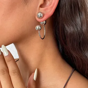 Gros plan de boucles d'oreilles minimalistes en argent avec clous à billes et anneau en C