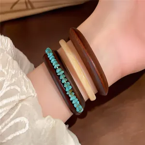 Macro detail van onregelmatige houten en hars armbanden met turkoois chips om een elegante pols