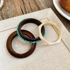 Gedetailleerde opname van drie onregelmatige geometrische hars en houten armbanden