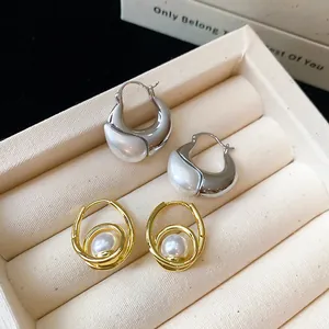 Macro detail view of French vintage gold and silver hoop earrings with elegant pearl accents