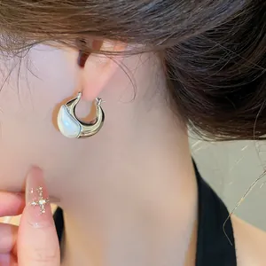Detail view of a French vintage silver earring with a white pearl drop worn on ear