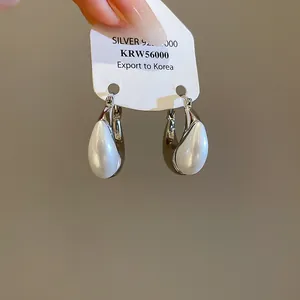 Close-up of French vintage water drop pearl earrings with silver finish on card