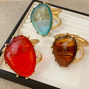 Detailansicht von drei klobigen Harzarmbändern mit einzigartigen goldenen Hohlfassungen