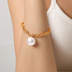 Gros plan du bracelet chaîne dorée avec grande perle baroque