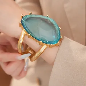 Detailansicht eines luxuriösen Statement-Armreifens aus Harz mit goldfarbenem Hohlband am Modell