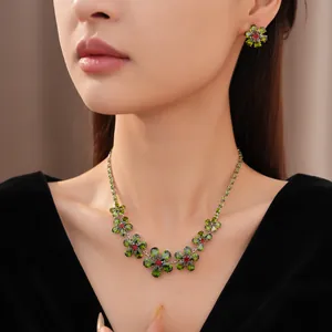 Detailansicht von Vintage-Halskette und Ohrringen mit grünen Zirkonblumen