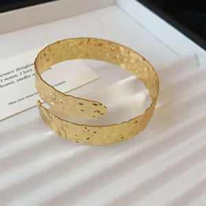 Gedetailleerde macro-opname van goud gehamerde textuur op de brede armband