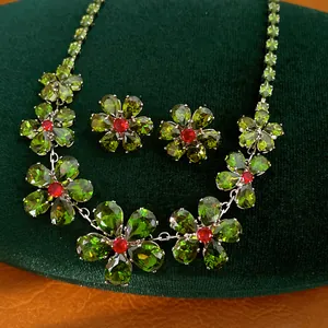 Detailansicht eines Vintage-Schmucksets mit grünen Zirkonia-Blumen und roten Zentren
