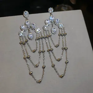 Macro view of luxurious silver tassel earrings with sparkling oval zircon stones