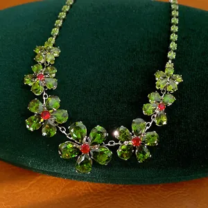 Detailansicht einer Vintage-Blumenhalskette mit grünen Zirkonia und roter Mitte
