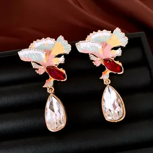 Detailed view of elegant fan-shaped enamel earrings featuring clear teardrop crystal pendants