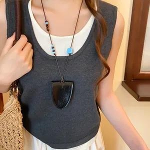 Nahaufnahme einer Vintage-Lederanhänger-Kette mit blauen Perlen und Brillenhalter.