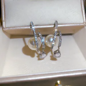 Close-up detail of elegant French style drop earrings with pearls and cubic zirconia