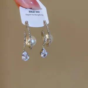 Close-up of luxury zircon pearl water-drop pendant earrings on a display card