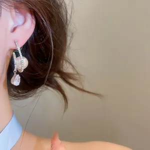 Elegant French style zircon pearl teardrop pendant earrings shown on model ear.