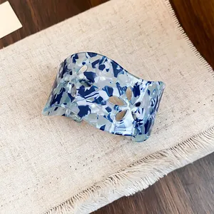 Detaillierte Nahaufnahme einer blauen Acryl-Armspange mit ausgehöhlten floralen Mustern
