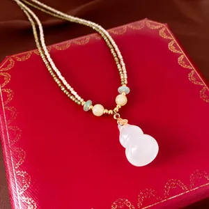 Macro view of double-layered beaded necklace with white chalcedony gourd pendant detail