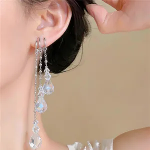 Close-up of elegant layered silver tassel earrings with clear faceted crystal beads