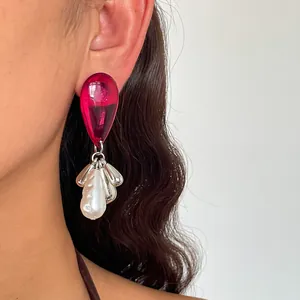 Macro view of vintage acrylic waterdrop earring with silver tassel and baroque pearl