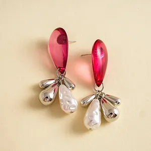 Close-up of vintage red acrylic and pearl teardrop tassel drop earrings